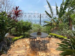 Casa Flor de Pajaro, vistas panorámicas increíbles al lago في Suchitoto: طاولة وكراسي في حديقة بها سياج