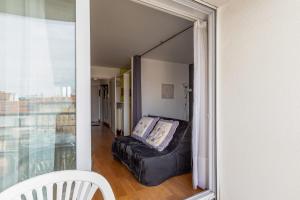 - une chambre avec un canapé et une fenêtre dans l'établissement Très bel appartement avec balcon au coeur de La Rochelle - Welkeys, à La Rochelle