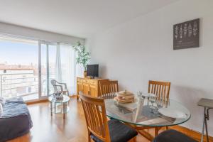 Appartement Petit coin de paradis - Welkeys في لا روشيل: غرفة معيشة مع طاولة وكراسي زجاجية