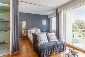 1 dormitorio con cama y ventana grande en Appartement Petit coin de paradis - Welkeys, en La Rochelle