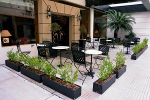 a patio with tables and chairs and plants at Centuria Hotel Buenos Aires in Buenos Aires