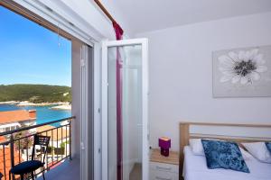 a bedroom with a bed and a balcony with a view at Apartment 'MIMO' in Milna - Hvar in Milna