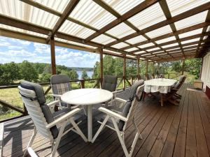 een veranda met een tafel en stoelen op een terras bij Holiday home RIMFORSA V in Rimforsa