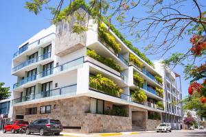 un edificio de apartamentos con plantas en los balcones en Opal Suites Apartments en Playa del Carmen