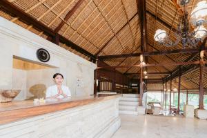 a woman sitting at a bar in a building at Pertiwi Resort & Spa in Ubud