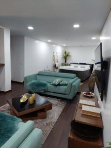Luxury Vila with Spa and Pool في فيلا دو كوندي: غرفة معيشة مع أريكة خضراء وطاولة