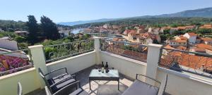 a balcony with a table and chairs and a city at Apartment On the top in Vrboska