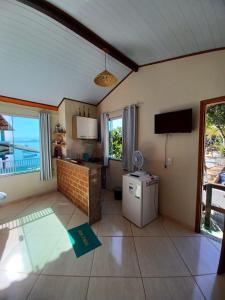 a kitchen with a small refrigerator and a television at Flat do Léo in Praia de Araçatiba