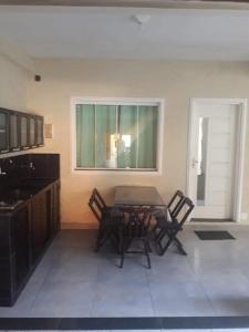 Un comedor con mesa y sillas y una ventana. en Suíte Caminho do Sol, en Arraial do Cabo