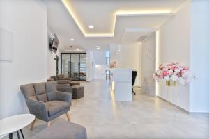 a lobby with chairs and a table and flowers at Aparthotel Remaneo in Promajna