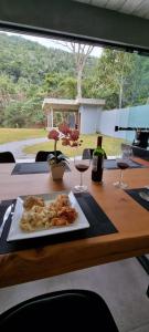 a plate of food on a table with wine glasses at Casa Deck videiras in Rio de Janeiro