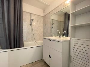 łazienka z umywalką, wanną i prysznicem w obiekcie Duplex 3 pièces rénové avec loggia et garage, cœur de Briançon, proche télécabine, 4-6 couchages - FR-1-330C-130 w mieście Briançon
