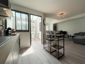 kuchnia i salon ze stołem i kanapą w obiekcie Duplex 3 pièces rénové avec loggia et garage, cœur de Briançon, proche télécabine, 4-6 couchages - FR-1-330C-130 w mieście Briançon