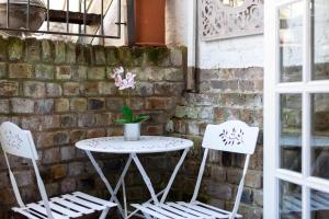 two chairs and a table with a potted plant on it at Fantastic 1 bedroom apartment with private patio in London