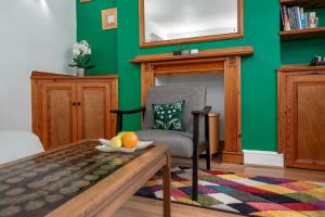 a green living room with a chair and a table at Fantastic 1 bedroom apartment with private patio in London