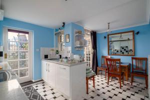 a kitchen with blue walls and a table and chairs at Fantastic 1 bedroom apartment with private patio in London
