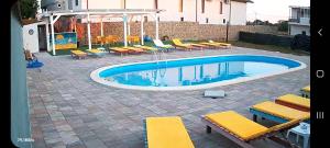 a swimming pool with chairs and a bunch ofitures at camere de închiriat Duly Costinești in Costinesti