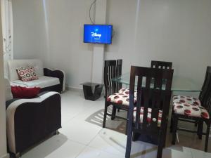 a living room with chairs and a table and a tv at Apartamentos en Huanchaco in Huanchaco