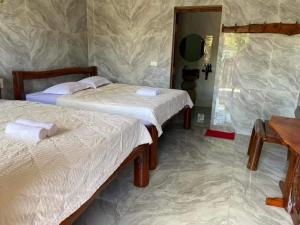 A bed or beds in a room at Green Bamboo Lodge Resort