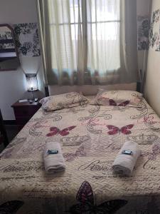 a bed with two towels and butterflies on it at hostel 148 in Petrópolis