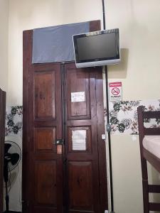 uma porta de madeira com uma televisão por cima em hostel 148 em Petrópolis