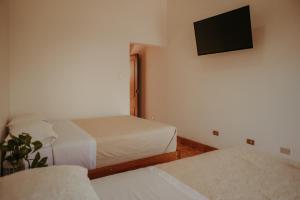 a room with two beds and a flat screen tv at Rosa Estela in Cieneguilla
