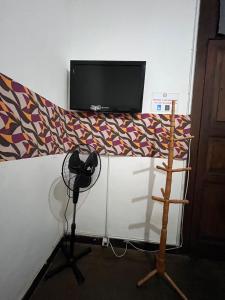 a room with a bed with a tv on top at hostel 148 in Petrópolis