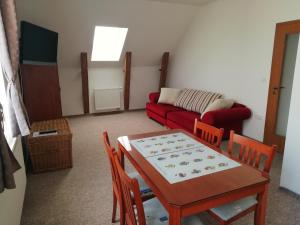 ein Wohnzimmer mit einem Tisch und einem roten Sofa in der Unterkunft Penzion Alma in Znojmo
