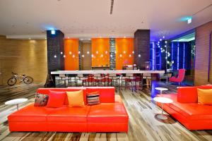 eine Lobby mit einem orangenen Sofa und einer Bar in der Unterkunft FX INN Kaohsiung Zhonghua Road Branch in Kaohsiung