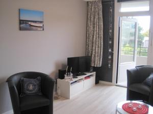 a living room with two chairs and a television at Apartment Marina Wendtorf in Wendtorf