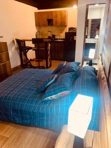 a bed with a blue comforter in a room at Apartamentos Plaza de la Independencia in Zipaquirá