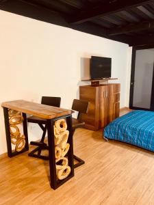 a room with a table and a bed and a television at Apartamentos Plaza de la Independencia in Zipaquirá