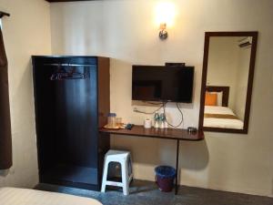 a room with a desk with a television and a mirror at One World Hotel in Kulai