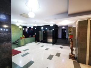 a lobby with a tile floor and a hallway with elevators at Hotel Severus in Zalău