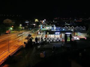 Una ciudad de noche con coches estacionados en un estacionamiento en Hotel Severus en Zalău