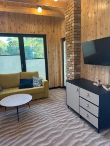 a living room with a couch and a tv at Wiatr od morza Jantar - BursztynoveLove in Jantar