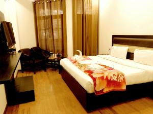 a hotel room with a bed and a desk and a room at Hotel Crystal Palace in Mussoorie