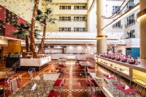 a hotel lobby with tables and chairs and palm trees at Beijing XinQiao Hotel in Beijing