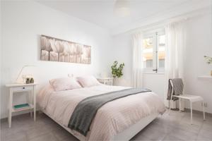 Un dormitorio blanco con una cama y un escritorio. en Apartamento Can Marce, en Cala de Sant Vicent