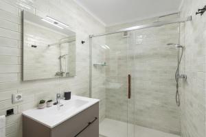 Un baño con lavabo y ducha de cristal. en Apartamento Can Marce, en Cala de Sant Vicent 28 fotos más