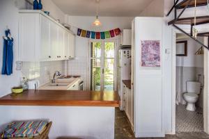 a kitchen with white cabinets and a sink and a toilet at Mola Home by halu! Villas in Mola Kalyva