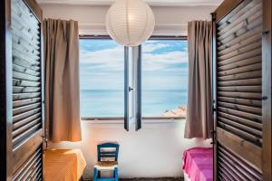 a room with a window with a view of the ocean at #Mola Home by halu! Villas in Mola Kalyva