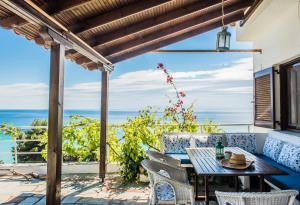 a patio with a table and chairs and a view of the ocean at #Mola Home by halu! Villas in Mola Kalyva