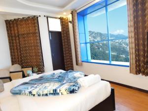a bedroom with a bed and a large window at Hotel Crystal Palace in Mussoorie