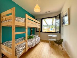 1 dormitorio con litera y mesa. en Maison moderne idéale famille à 10 mn de la plage en Labenne