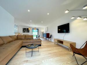 ein Wohnzimmer mit Couch und Flachbildfernseher in der Unterkunft Maison moderne idéale famille à 10 mn de la plage in Labenne