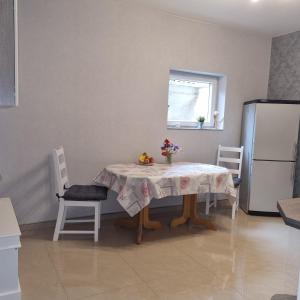 a kitchen with a table and a refrigerator at Ferienwohnung am Kupferbach in Wolfterode +10 photos