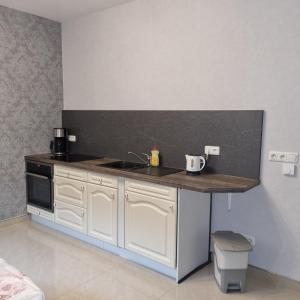 a kitchen with white cabinets and a counter top at Ferienwohnung am Kupferbach in Wolfterode