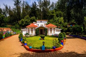 a small white house with an orange roof at goSTOPS Ooty in Ooty