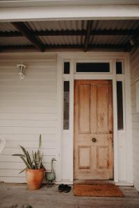 una porta d'ingresso di una casa con una pianta in vaso di The Allotment Albany - Centrally Located Cottage in Old Albany a Albany